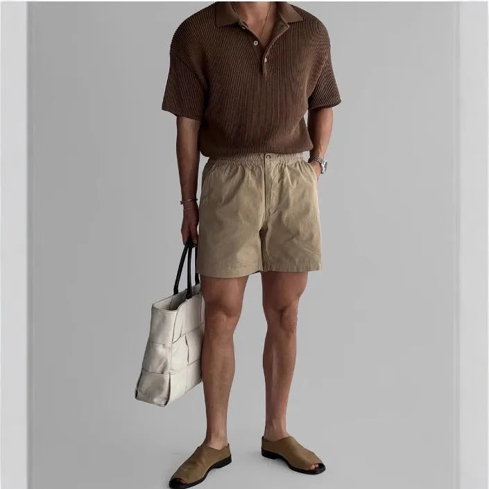 Man wearing black loose-fit cotton sports shorts for summer activity.
