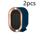 Compact black desktop ceramic fan heater with mechanical controls on a wooden desk.