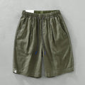Men's straight-leg linen shorts in black or green with drooping style and drawstring mid-waist.