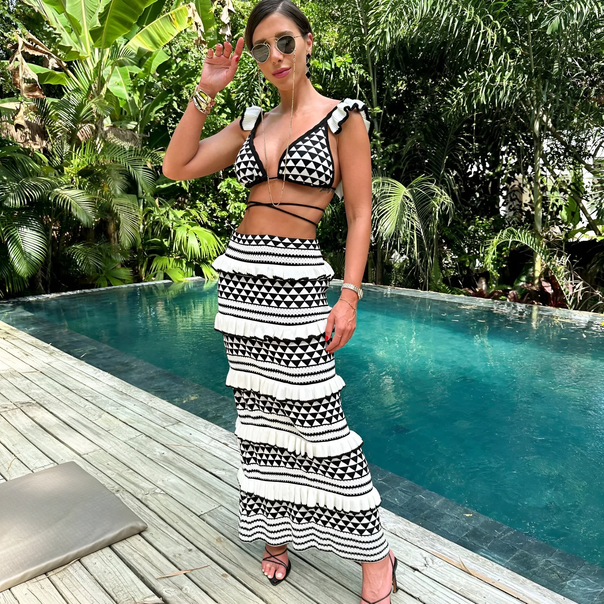 Black and white striped women's bikini set with ruffled spaghetti strap top and long knitted skirt.