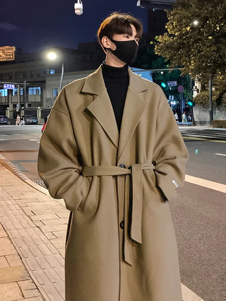 Men's British style mid-long wool coat in khaki with side seam pockets on a hanger