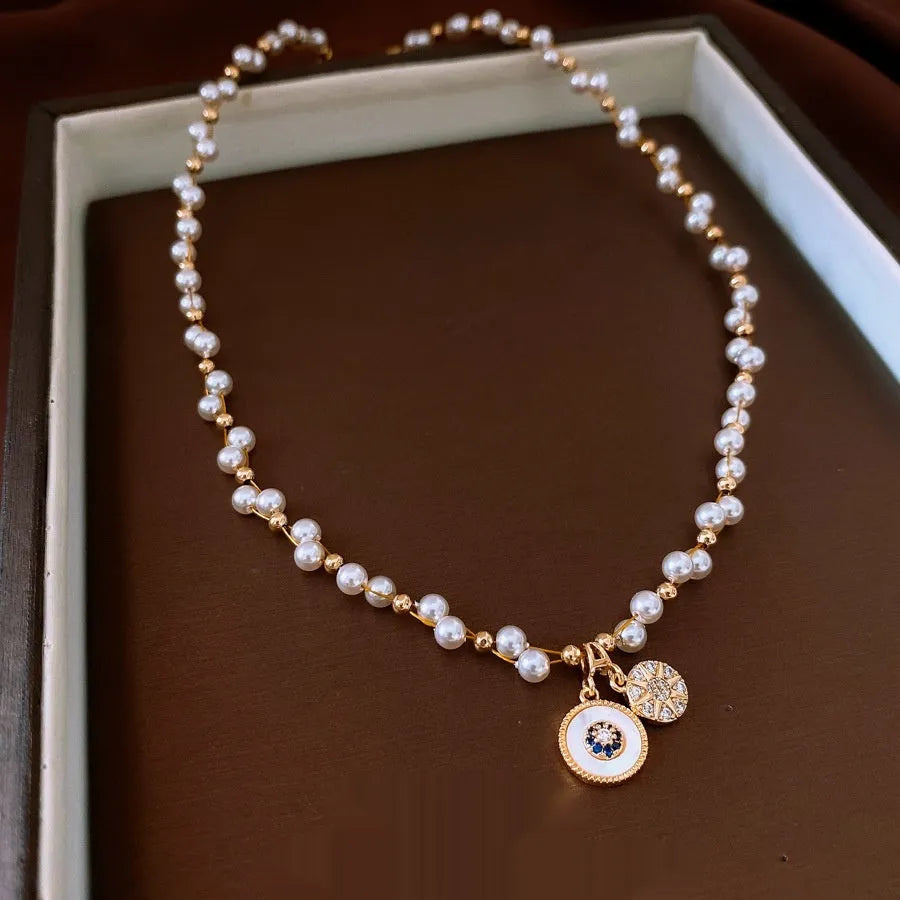 Gold electroplated women's clavicle necklace with round zircon pearl pendant on white background
