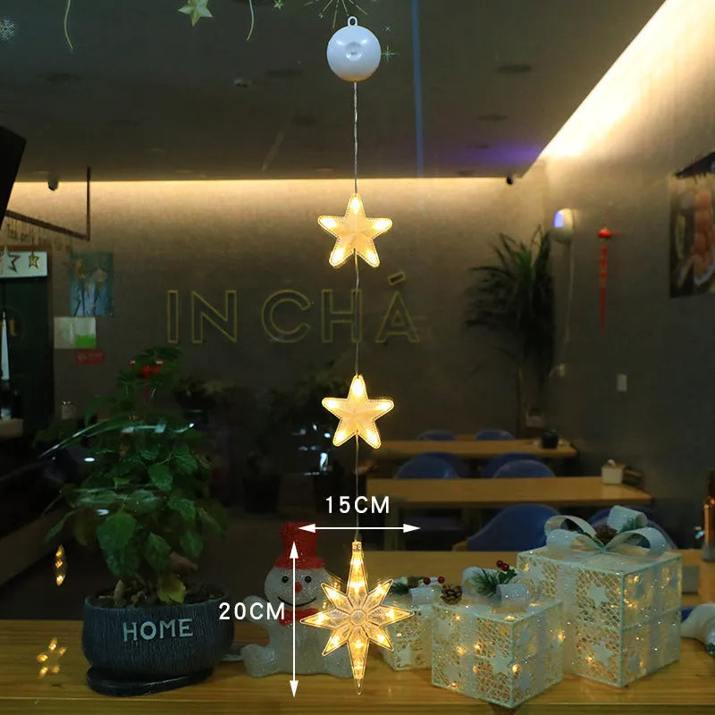 Three Christmas LED light ornaments with suction cups hanging on window