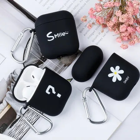 Black and pink polycarbonate AirPods case covers with decorative flower and smiley face back designs.
