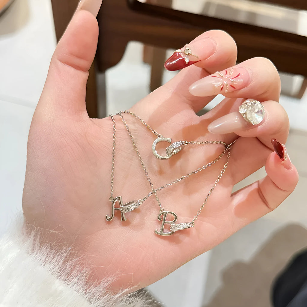 Women's 26-letter initial necklace in titanium steel with a round zircon pendant on a cross chain, colour option shown