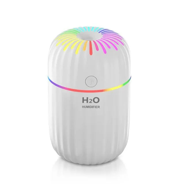 Small white USB portable humidifier with fireworks design on a wooden desk