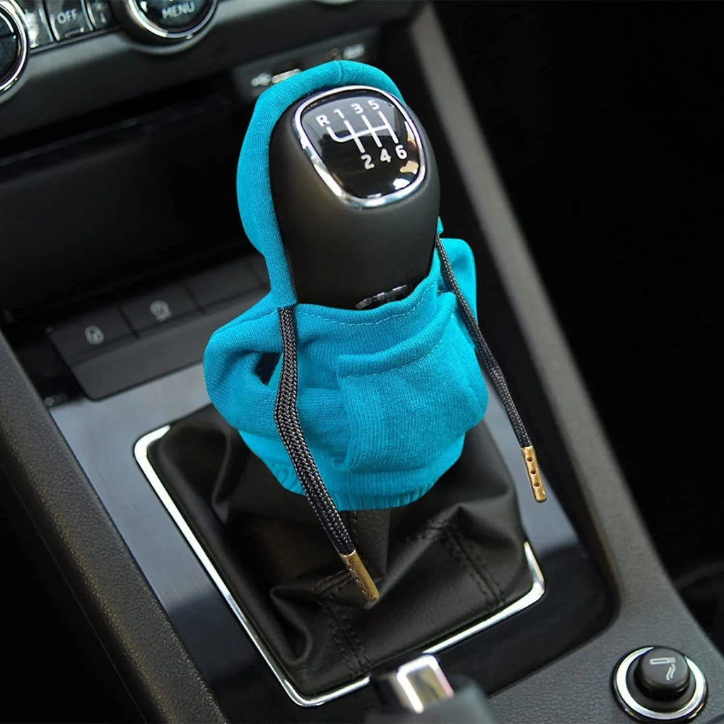 Blue cloth cover fitted over a car gear shift knob showing sewing detail