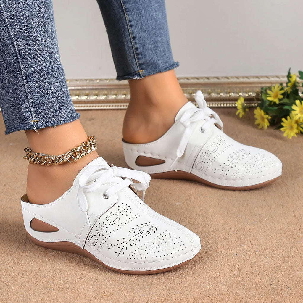 Women's black lace-up wedge slippers with hollow-out design, suede upper, and rubber sole.