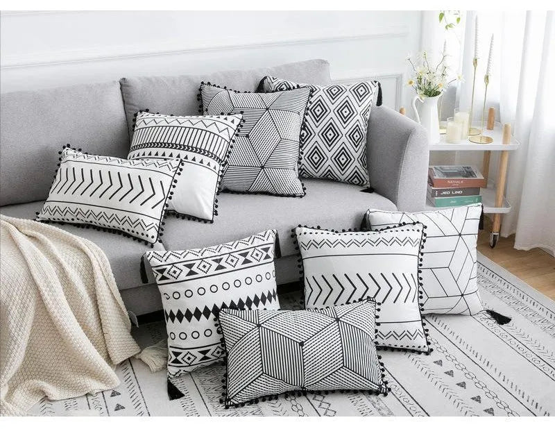 Bohemian national style throw pillow cushion cover in light grey on a sofa.