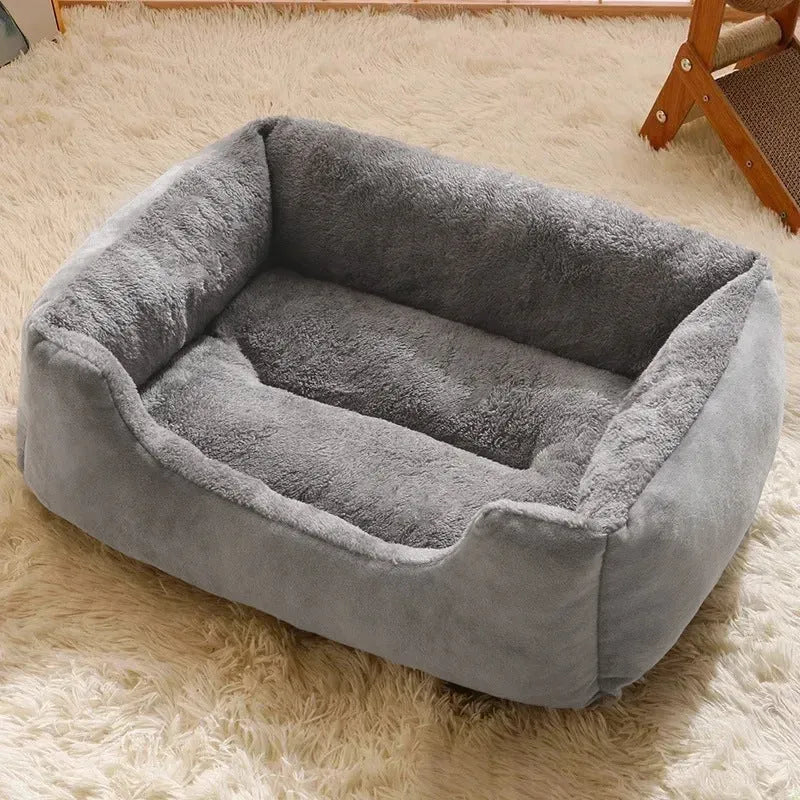 Soft short plush cat bed in grey, shown in a medium size for scale with a cat.