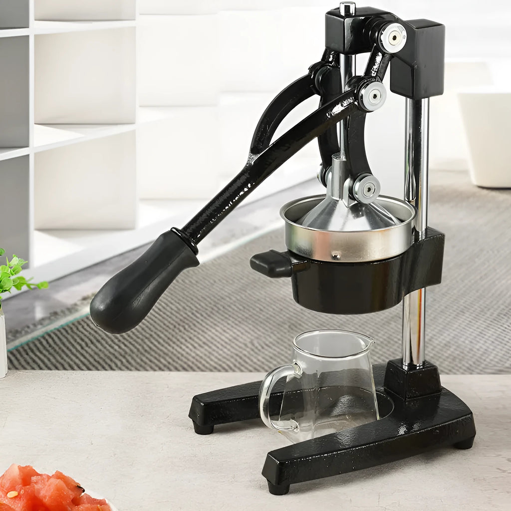Black cast iron manual citrus juicer with stainless steel cone on a white background