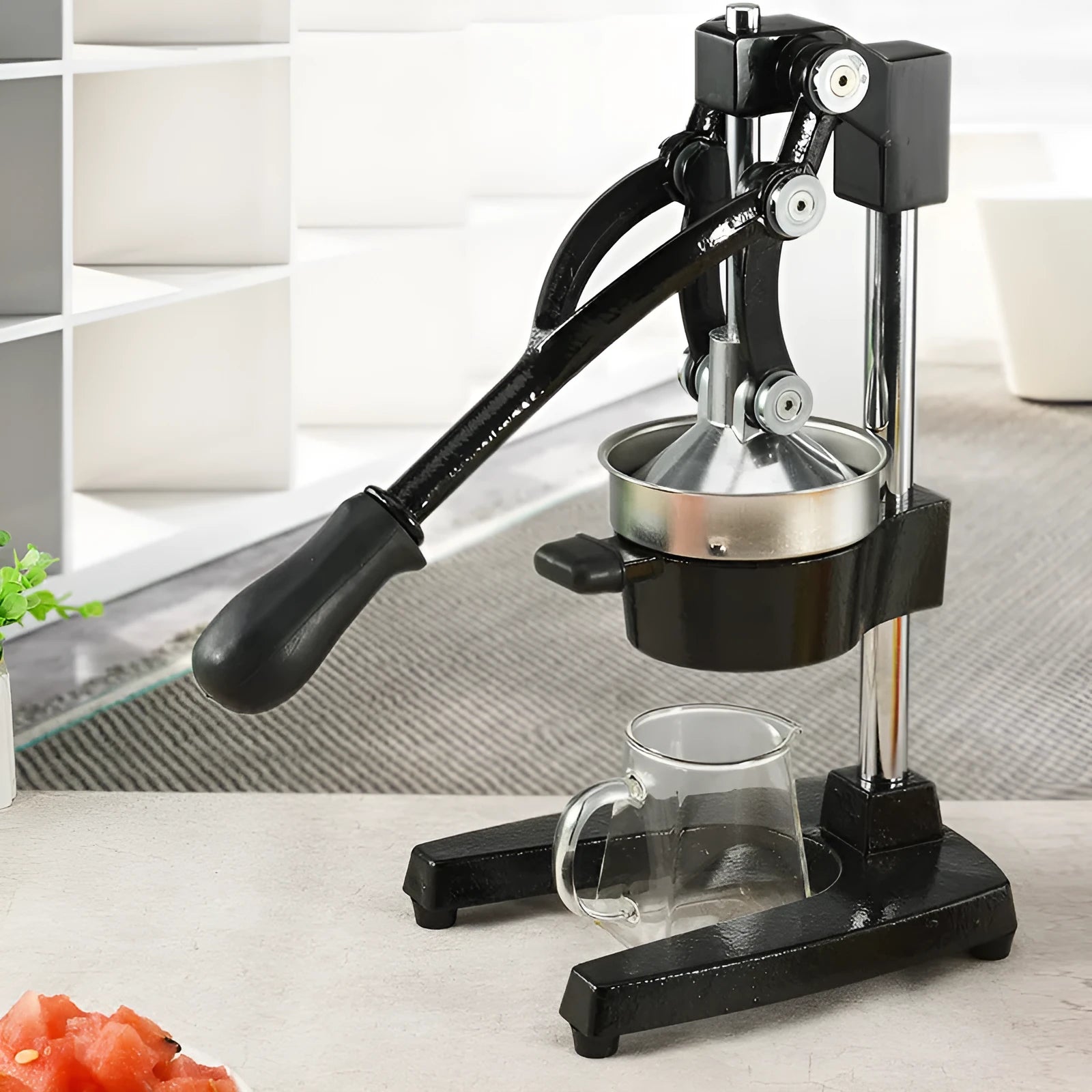 Black cast iron manual citrus juicer with stainless steel cone on a white background