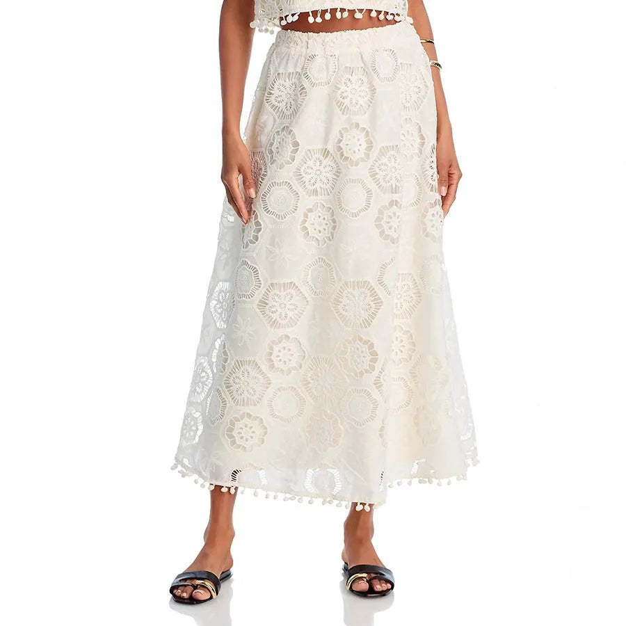 White women's polyester two-piece suit with embroidered detailing, featuring a sleeveless top and a long skirt.