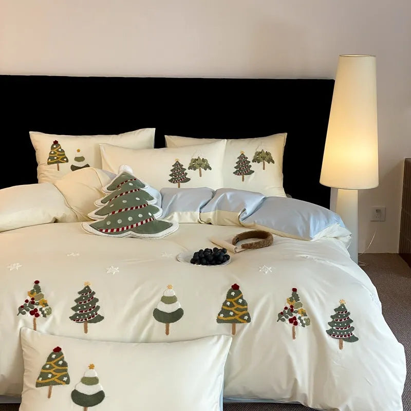 Pure cotton Christmas tree towel embroidery bedding four-piece set in cream blue on a bed.