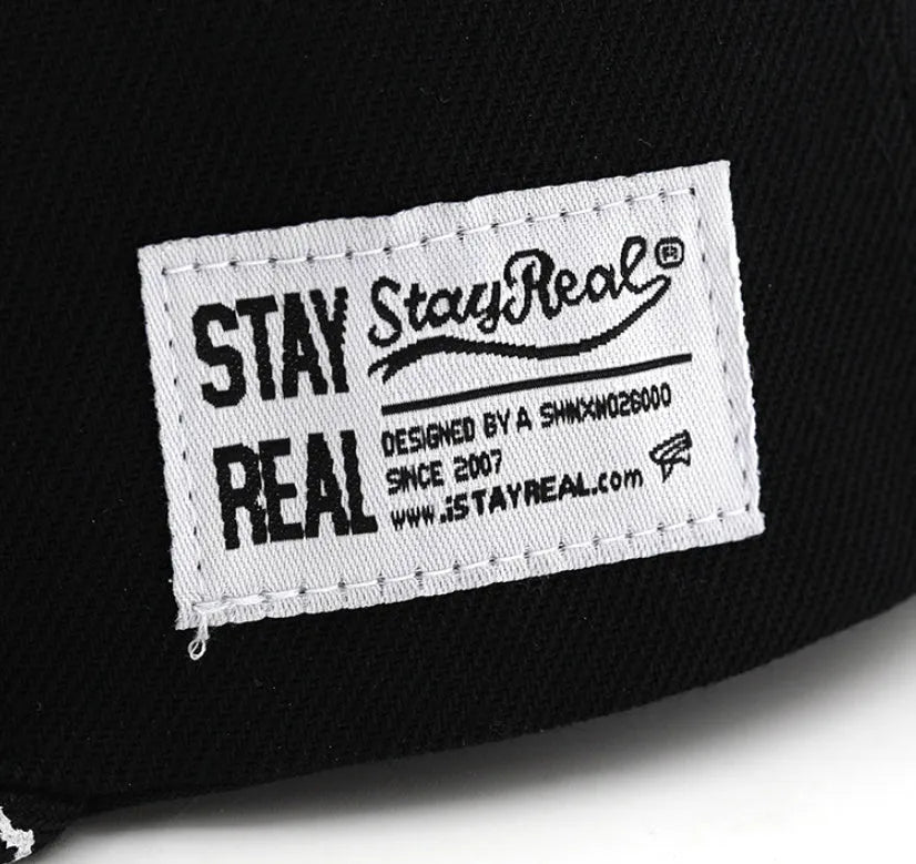 Black and white cotton baseball cap with embroidered letter design on the front.
