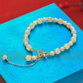 Women's bracelet with round Hetian jade pendant on gold-tone electroplated chain, Chinese-style design
