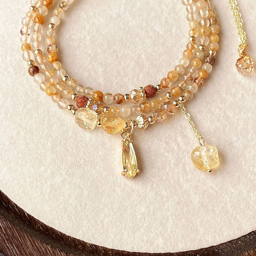 Women's gold natural citrine bracelet with three layered circles and Saturn design details.