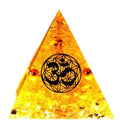 Small 6cm high clear epoxy resin pyramid ornament filled with colourful natural crystal gravel on a shelf.
