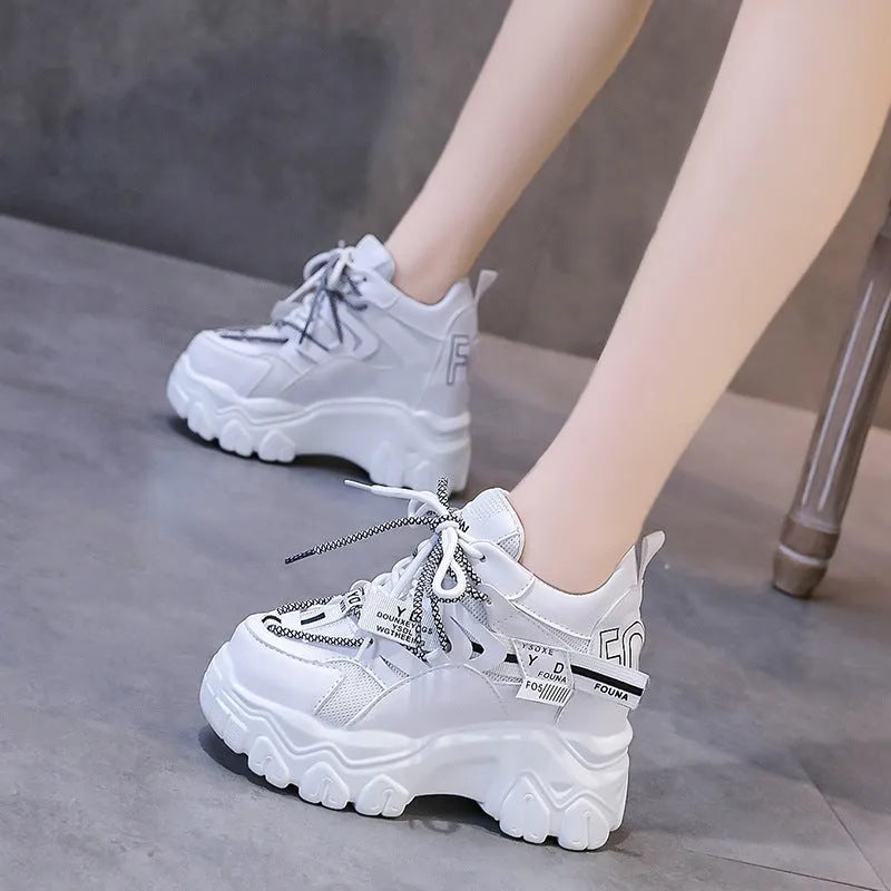 White women's platform sports shoes with mesh upper, cross strap, and a thick rubber sole.
