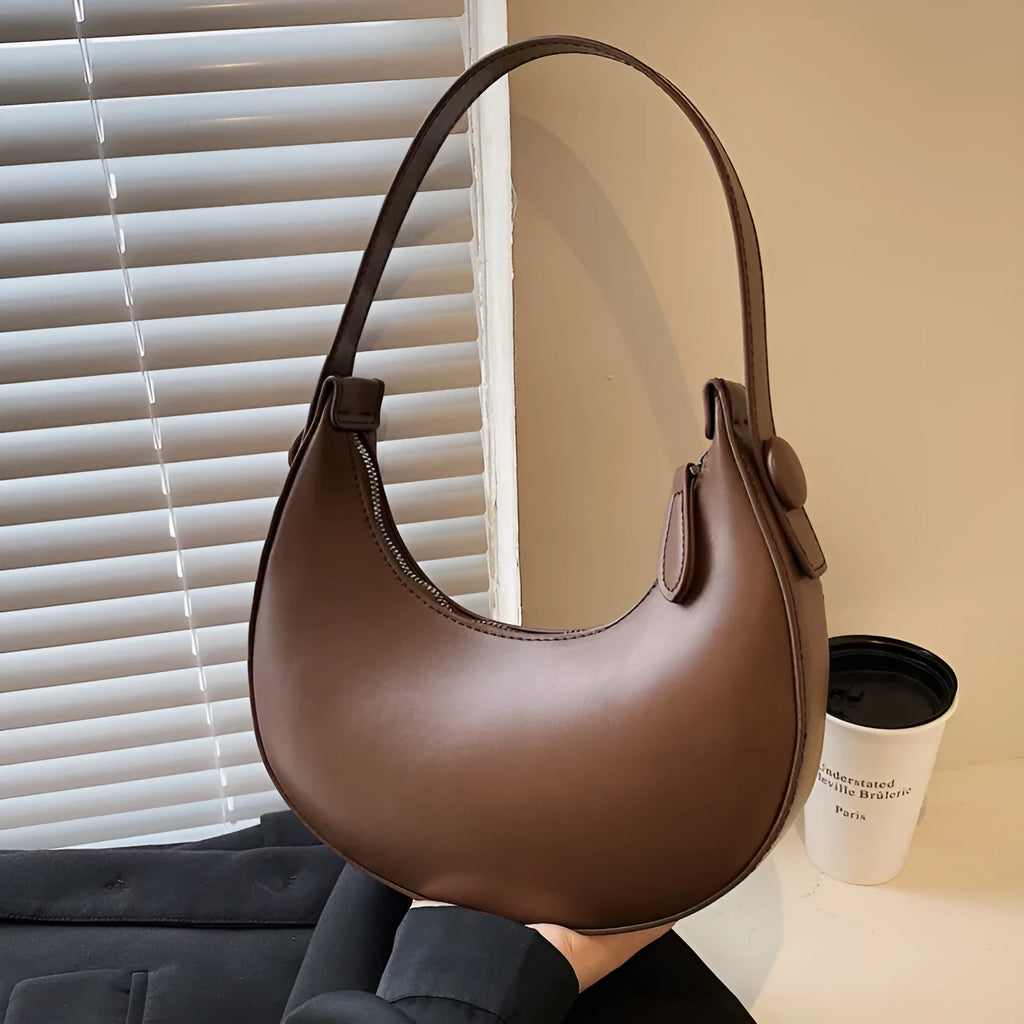 Women's retro dumpling-shaped shoulder bag in PU leather showing internal zipper pocket.