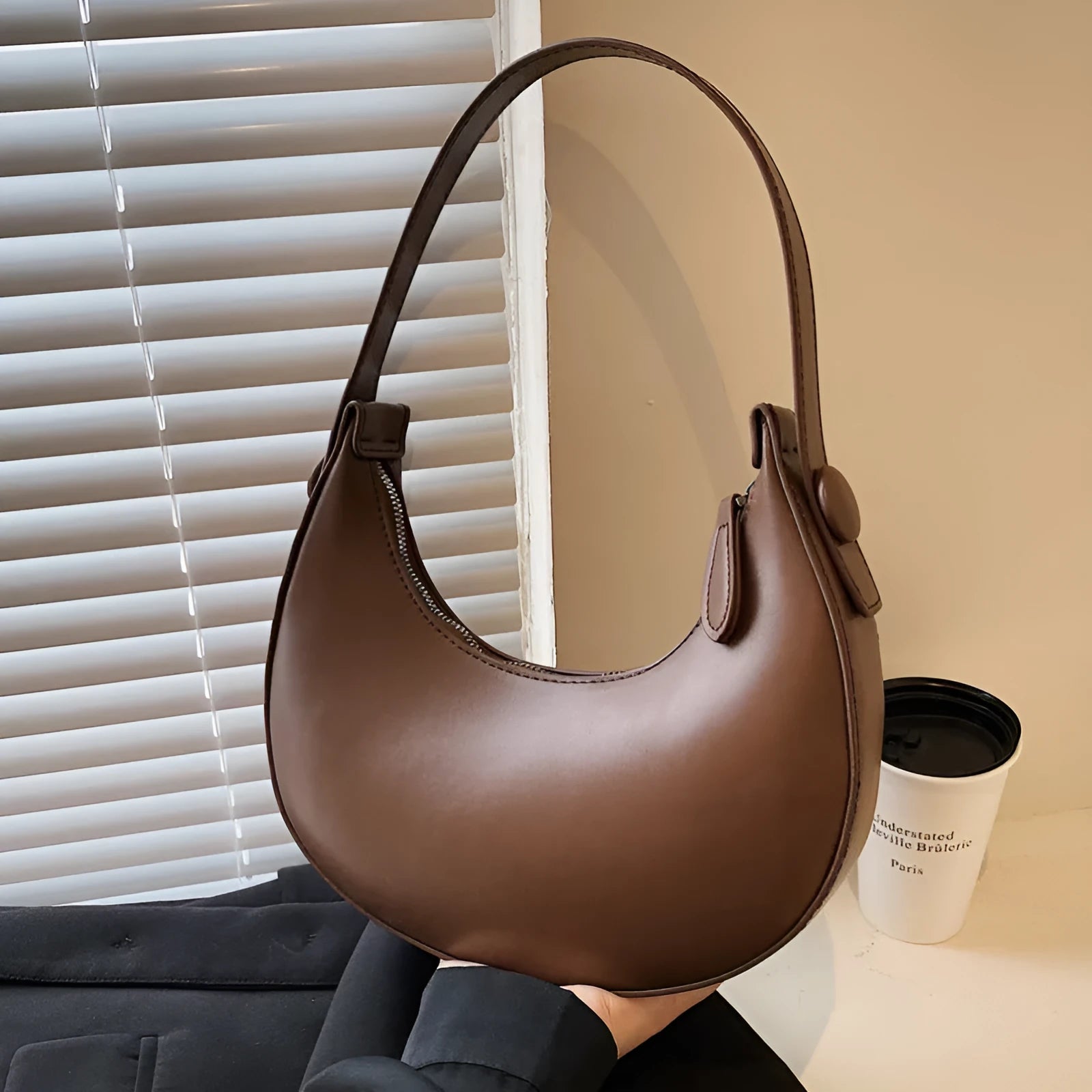 Women's retro dumpling-shaped shoulder bag in PU leather showing internal zipper pocket.