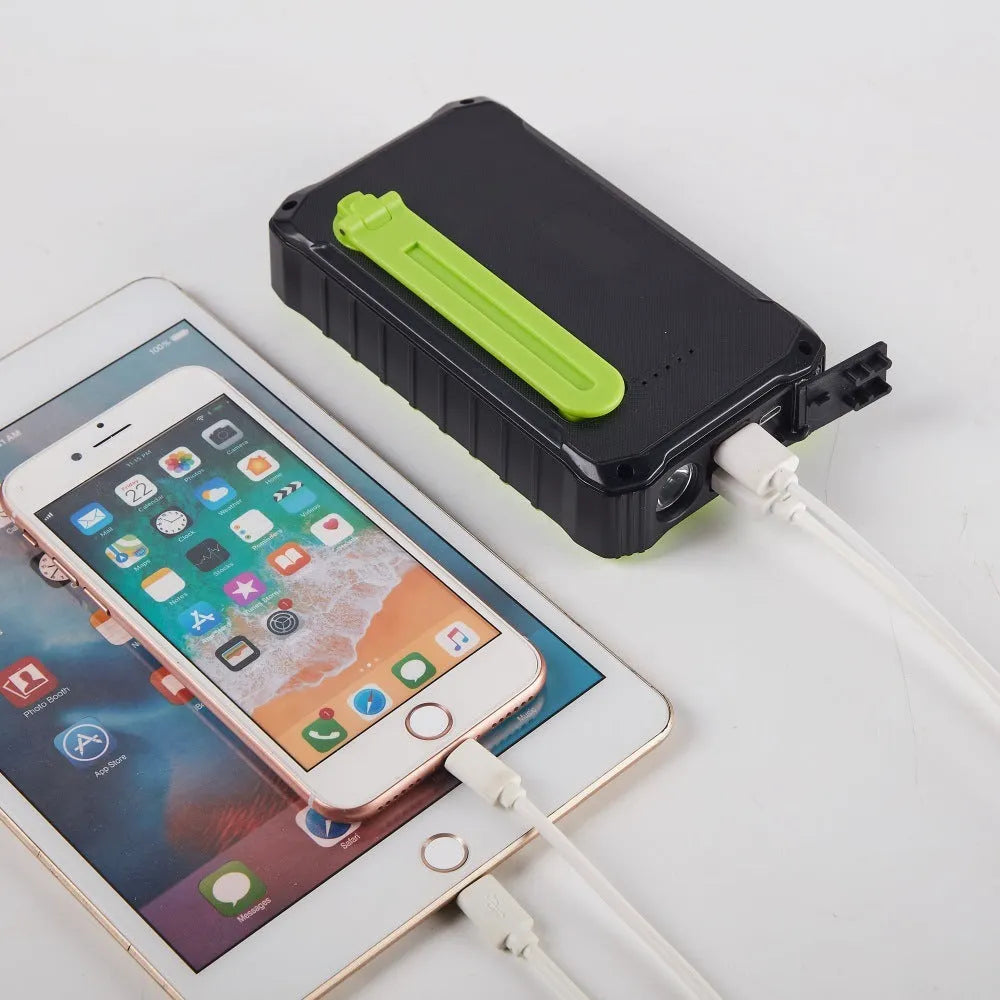 Orange portable solar power bank with hand crank and dual USB ports