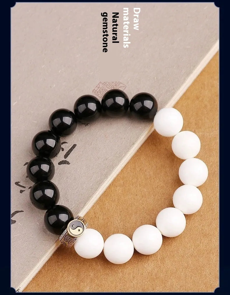 Black and white taiji bracelet with woven obsidian beads showing six word mantra and bagua symbol