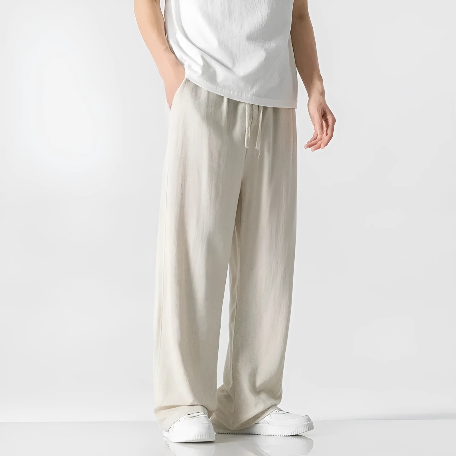 Man wearing beige cropped straight-leg linen trousers with a drawstring waist.