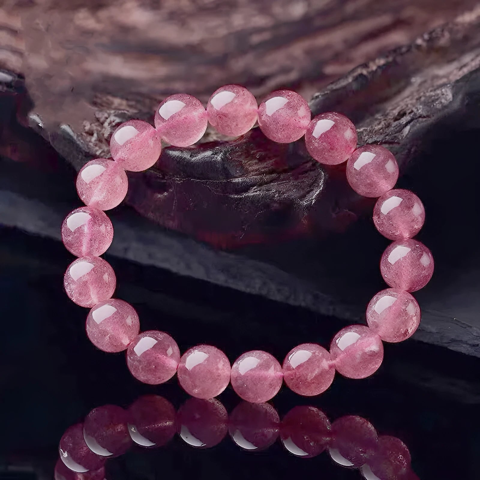 A bracelet made of round, polished pink strawberry quartz beads in three size options.