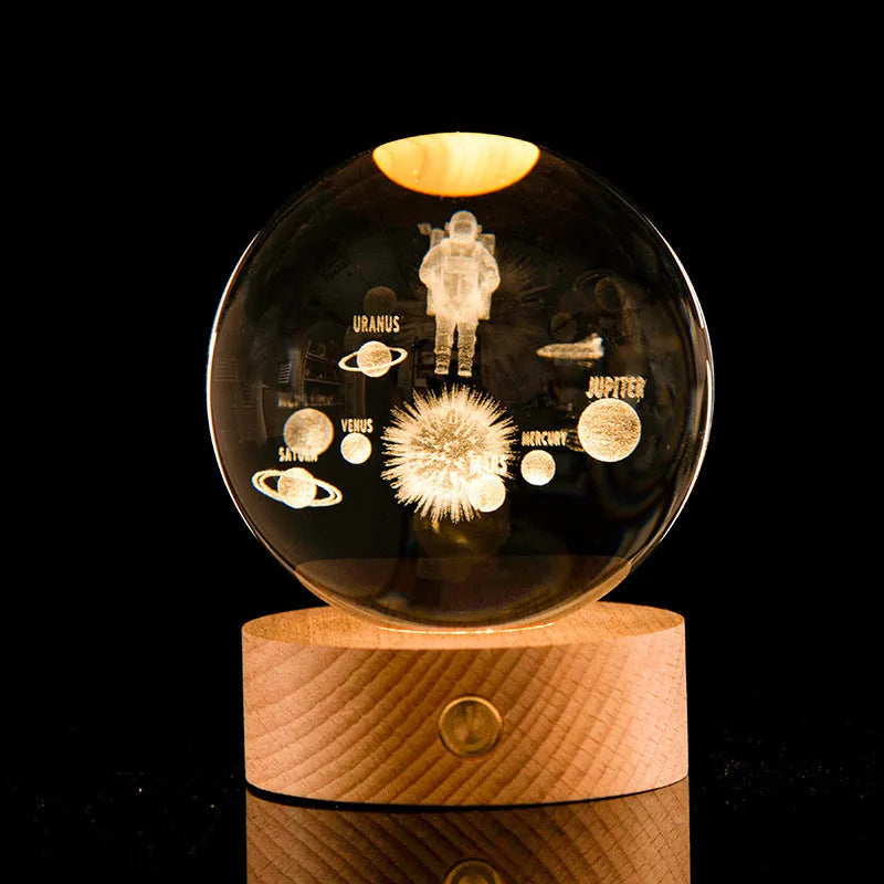 Transparent crystal ball with 3D laser inner carving of a galaxy on a beech wood base with warm light