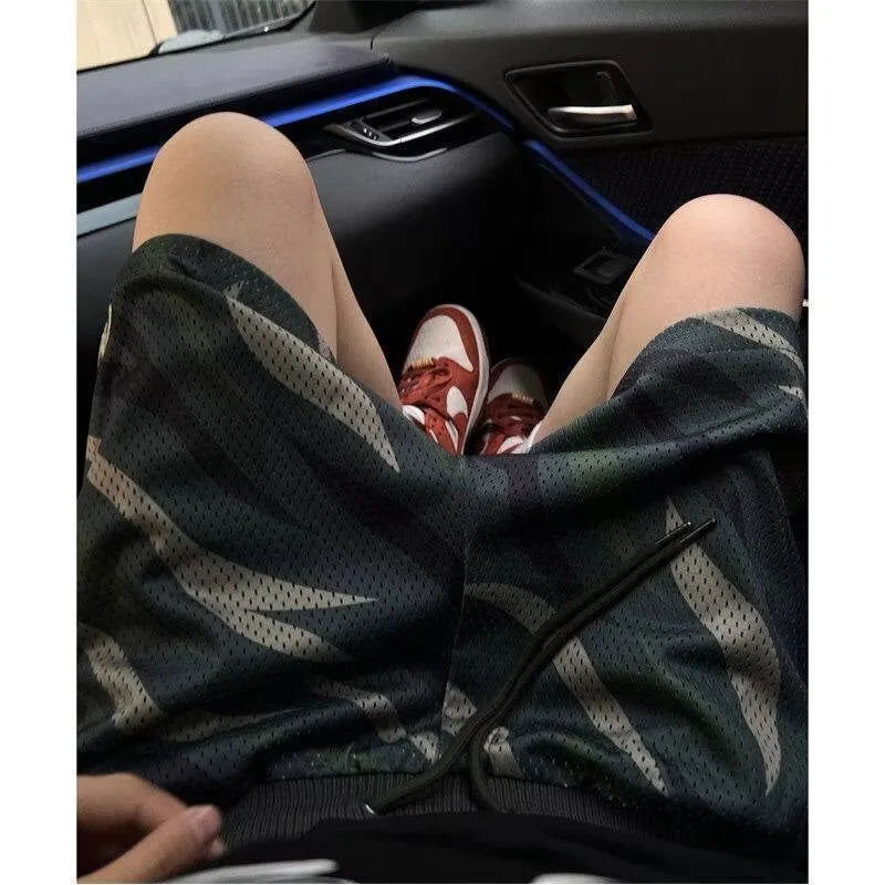 Men's camouflage pattern cotton blend straight-leg mesh shorts laid flat.