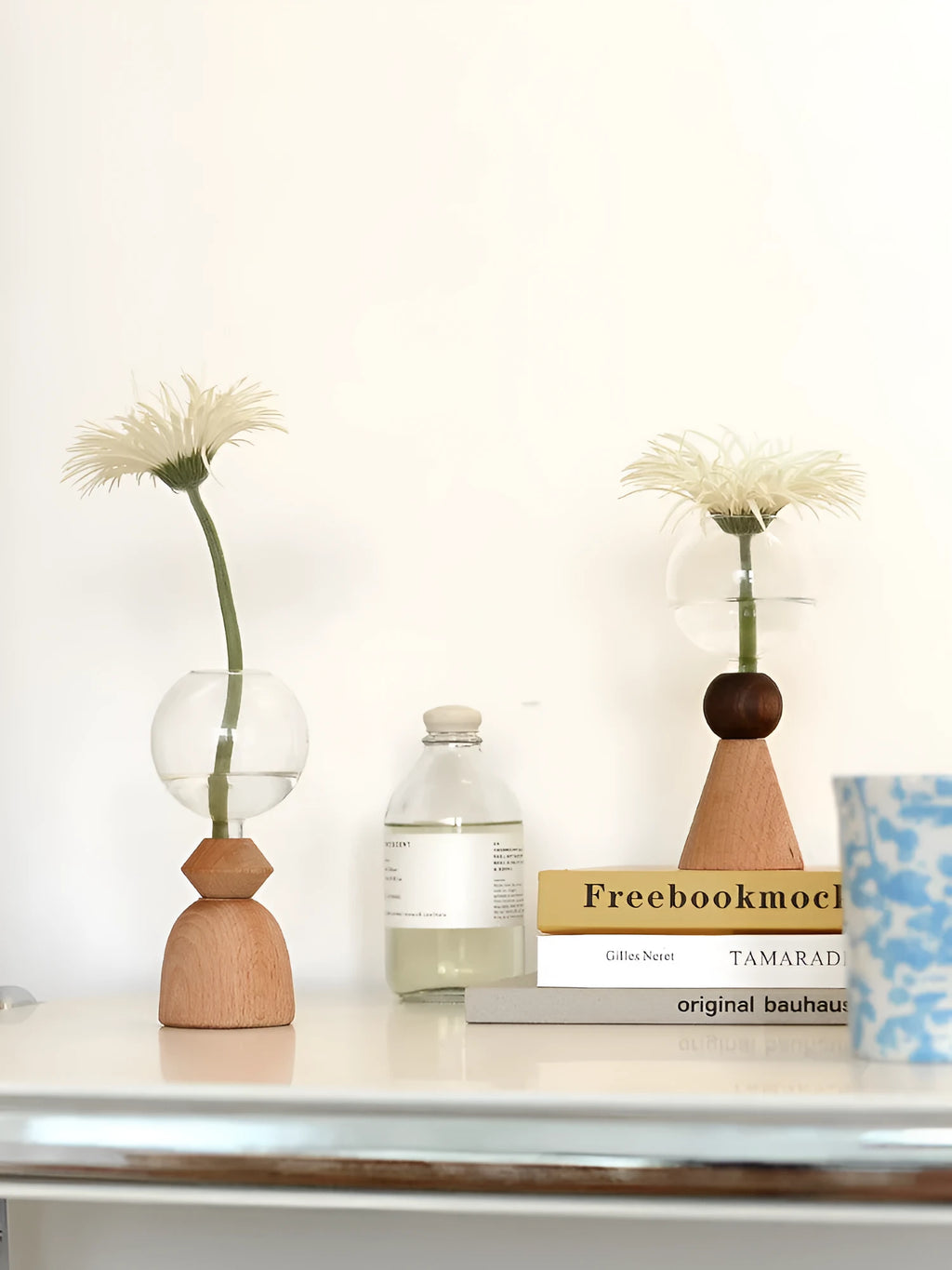 Clear glass Nordic geometric bubble vase with choice of conical base or curved arc base on a wooden table.