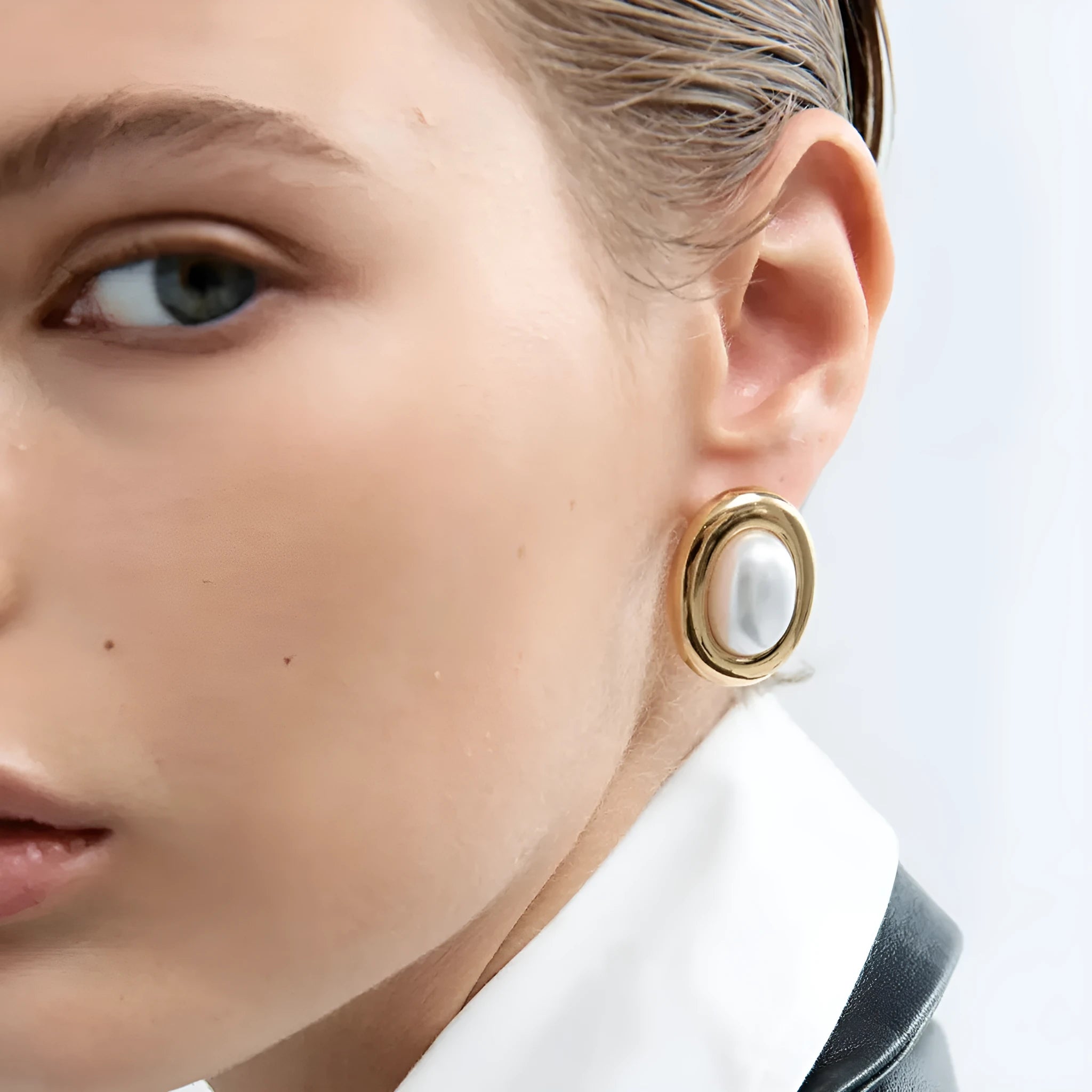 A pair of stainless steel vintage pearl stud earrings with a round pearl and electroplated finish.