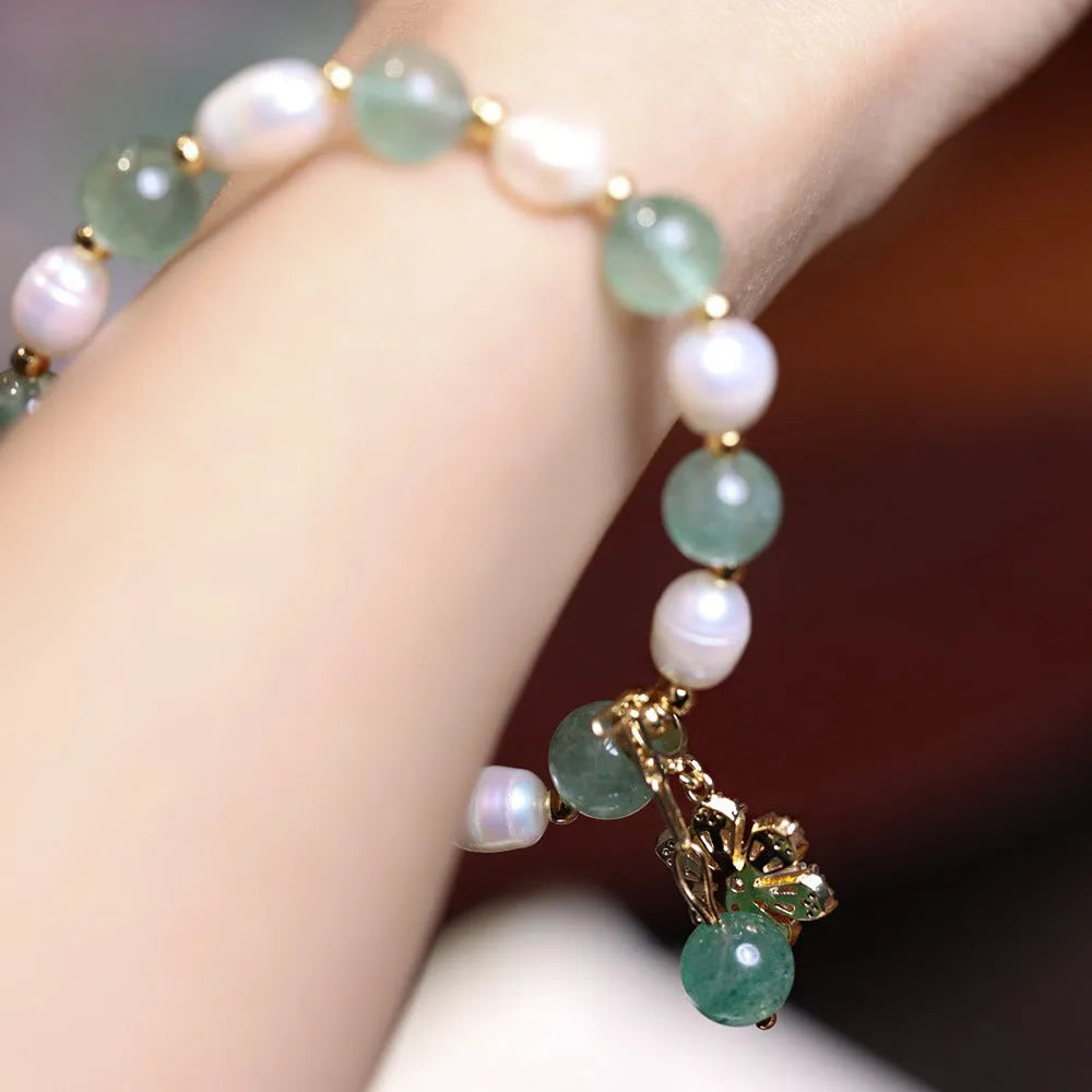 Green geometric strawberry freshwater pearl bracelet with small flower charm and Chinese knot design.