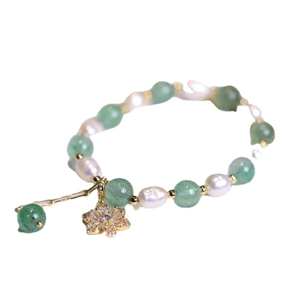 Green geometric strawberry freshwater pearl bracelet with small flower charm and Chinese knot design.