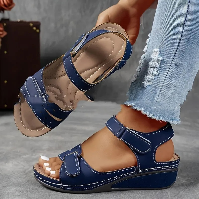Women's beige strap sandals with a Velcro fastener and thick composite sole, shown in a round toe design.