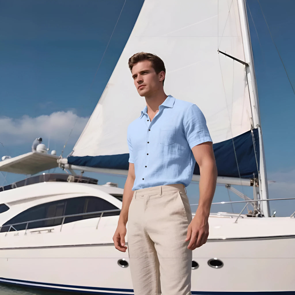 Man wearing a loose-fit light blue linen short-sleeved shirt in a casual setting.