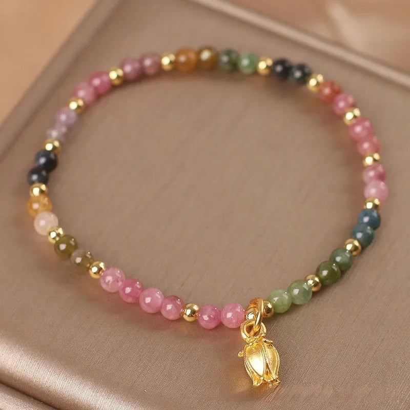 Natural tourmaline beaded floral anklet shown as adjustable bracelet on woman's wrist