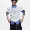 Man wearing a blue loose-fit short-sleeve shirt with a large cartoon print on the front.