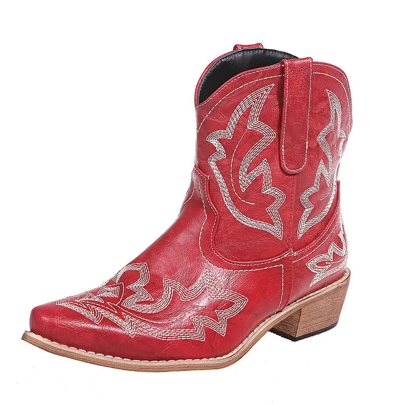 Blue women's cowboy boots with embroidery and a low wedge heel on a wooden floor.