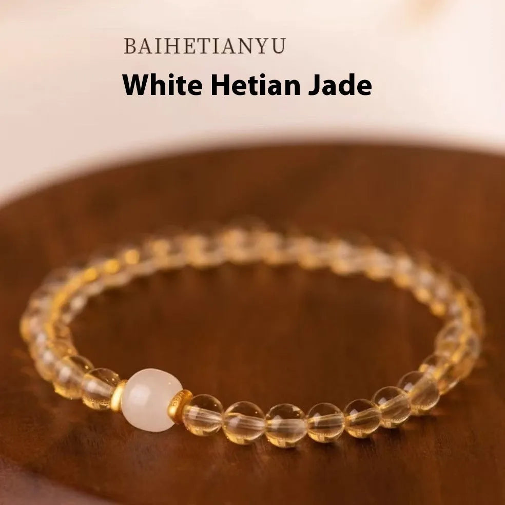 Close-up of a rutilated quartz bracelet showing gold rutile needles within green stone beads.