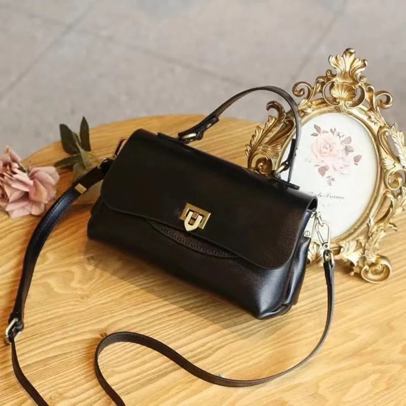Dark brown women's saddleback leather handbag with double straps and an open front pocket.