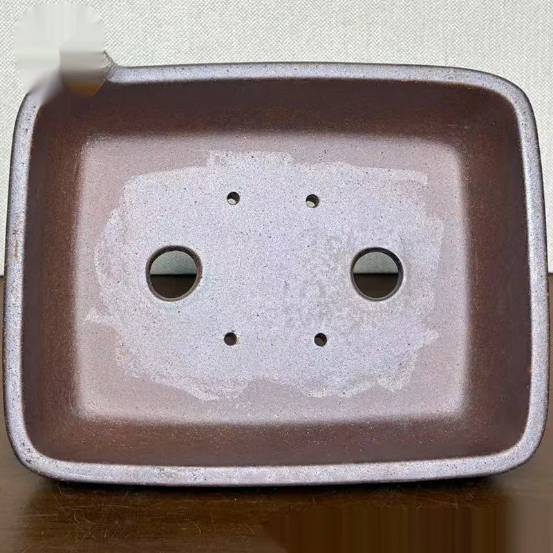 Light brown rectangular ceramic bonsai flower pot on a wooden surface