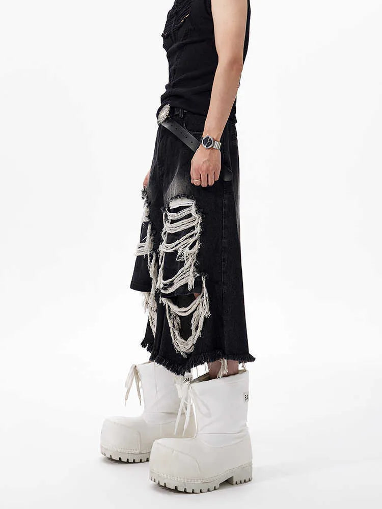 Woman wearing black distressed wide leg cropped jeans with ripped patches.