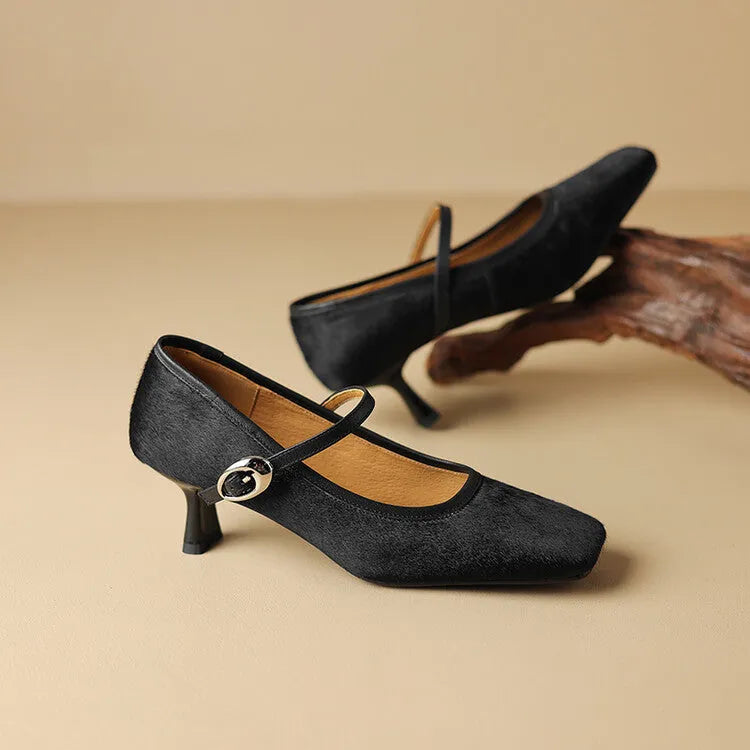 Women's black square toe stiletto heel ankle-strap shoes with horse hair upper on a plain background