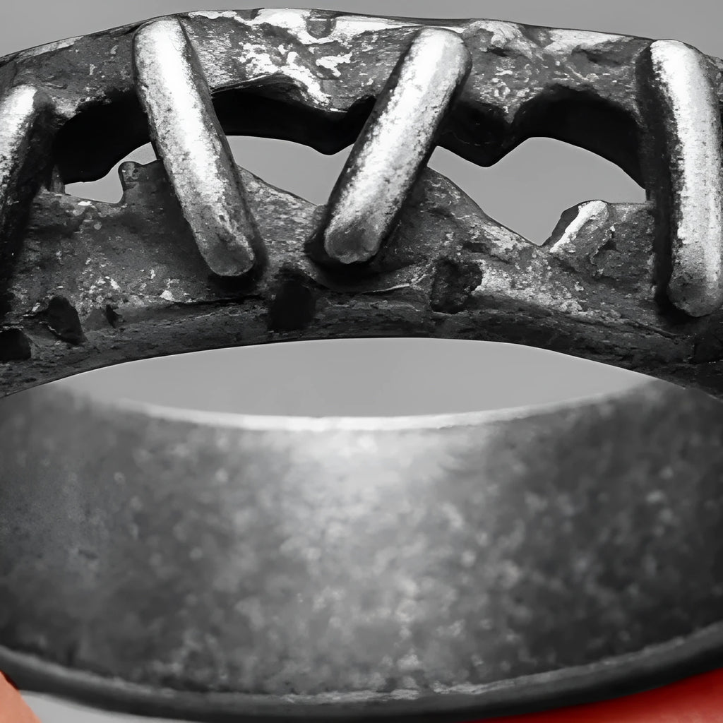 A dark-coloured stainless steel double ring with a punk stitching design pattern.