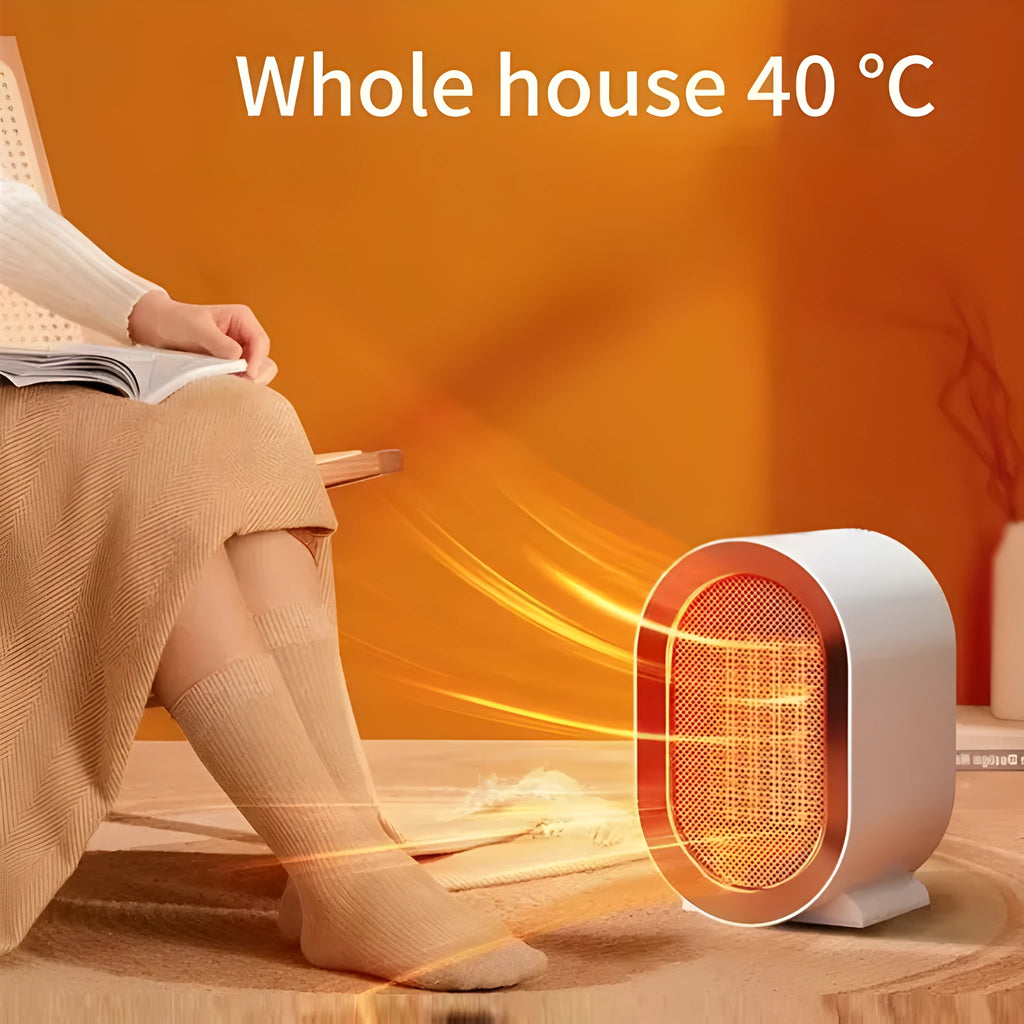 Compact black desktop ceramic fan heater with mechanical dials on a wooden desk.