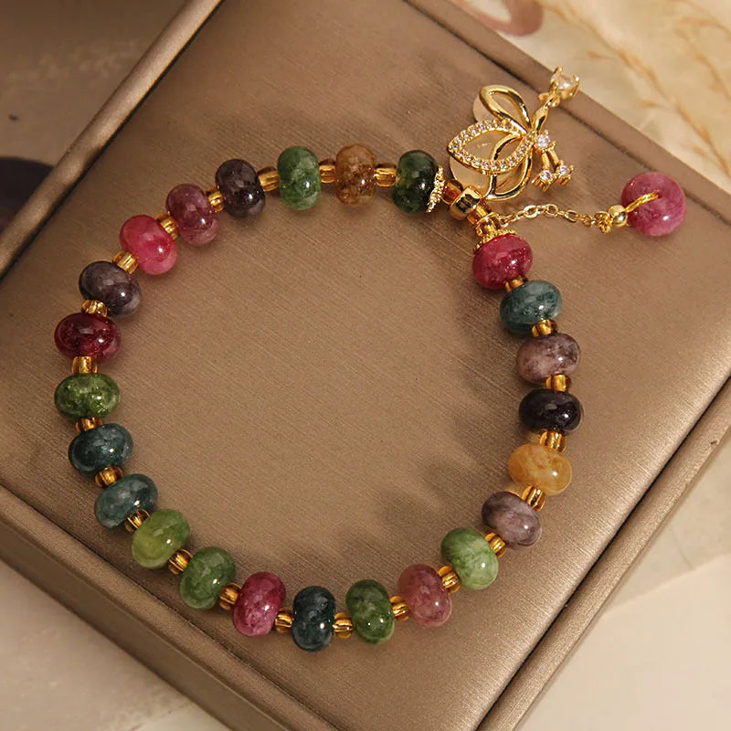 Colourful butterfly bracelet with alloy base and glass beads in tourmaline shades.