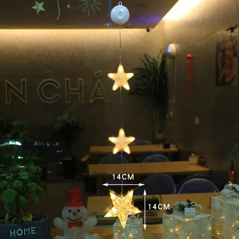 Three Christmas LED light ornaments with suction cups hanging on window