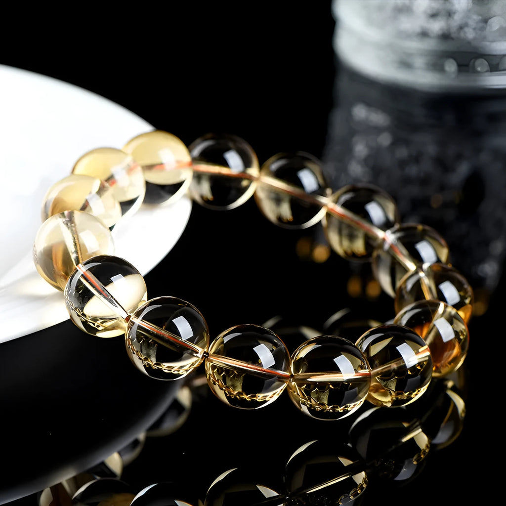 Handmade natural citrine scattered beads ball bracelet on a wrist, showing polished yellow gemstones.